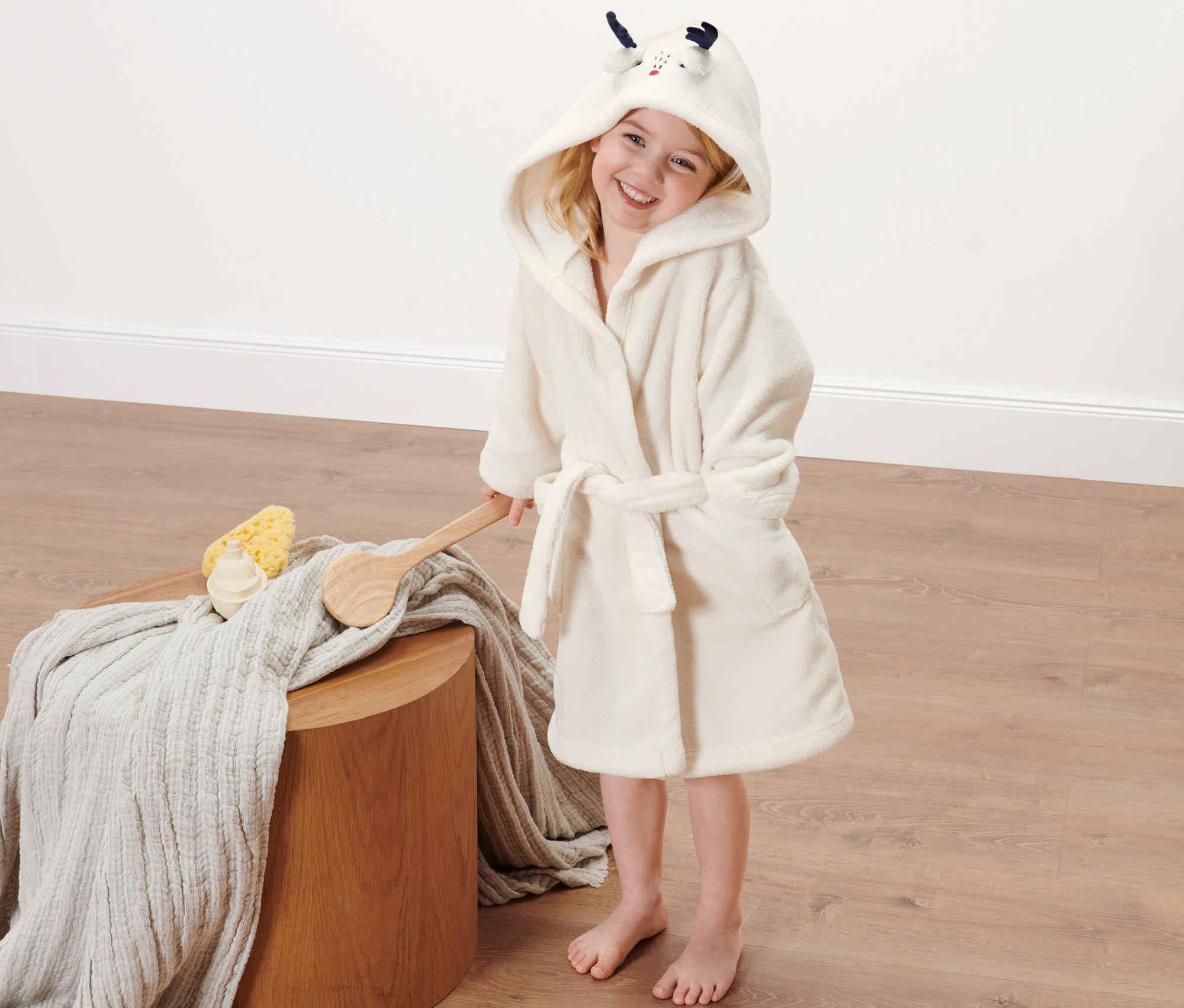 Dziewczynka w szlafroku dziecięcym z kapturem.