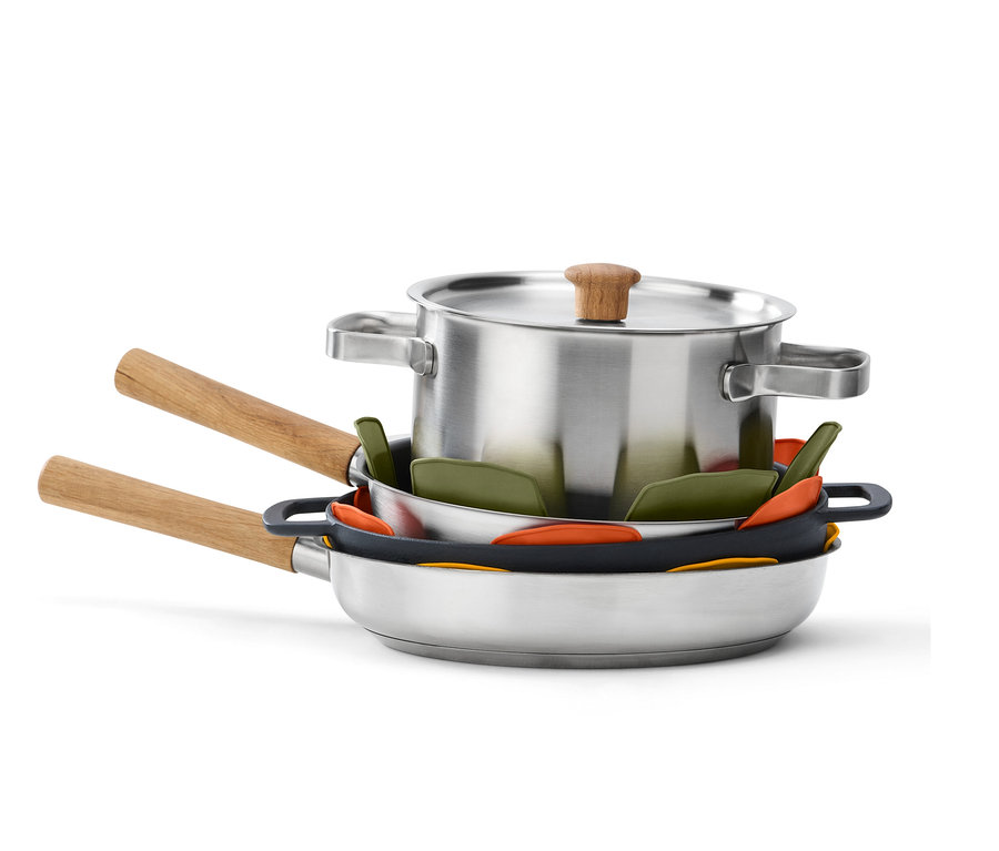 Zestaw garnka ze stali nierdzewnej z pokrywką i patelniami ułożony jest w stos z silikonowymi wkładkami ochronnymi do patelni (3 sztuki) pomiędzy nimi.