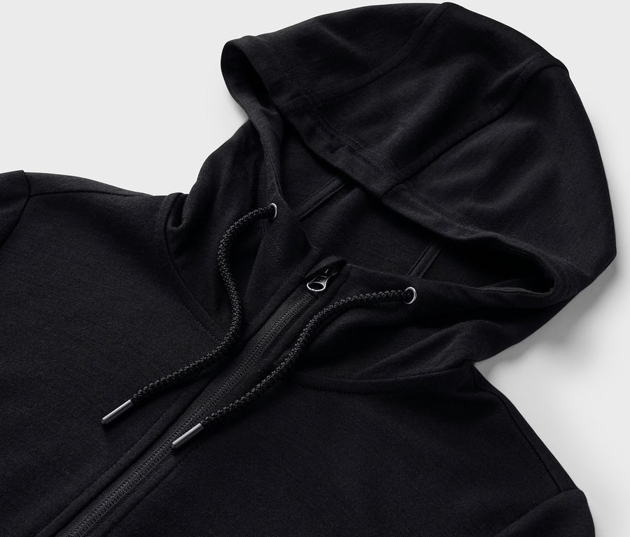 Zbliżenie czarnej bluzy z kapturem z wełną z certyfikatem RWS, zapinanej na zamek błyskawiczny.