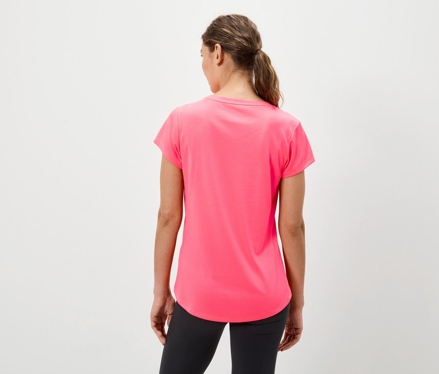 Kobieta tyłem do kamery ma na sobie różową koszulkę i czarne legginsy.