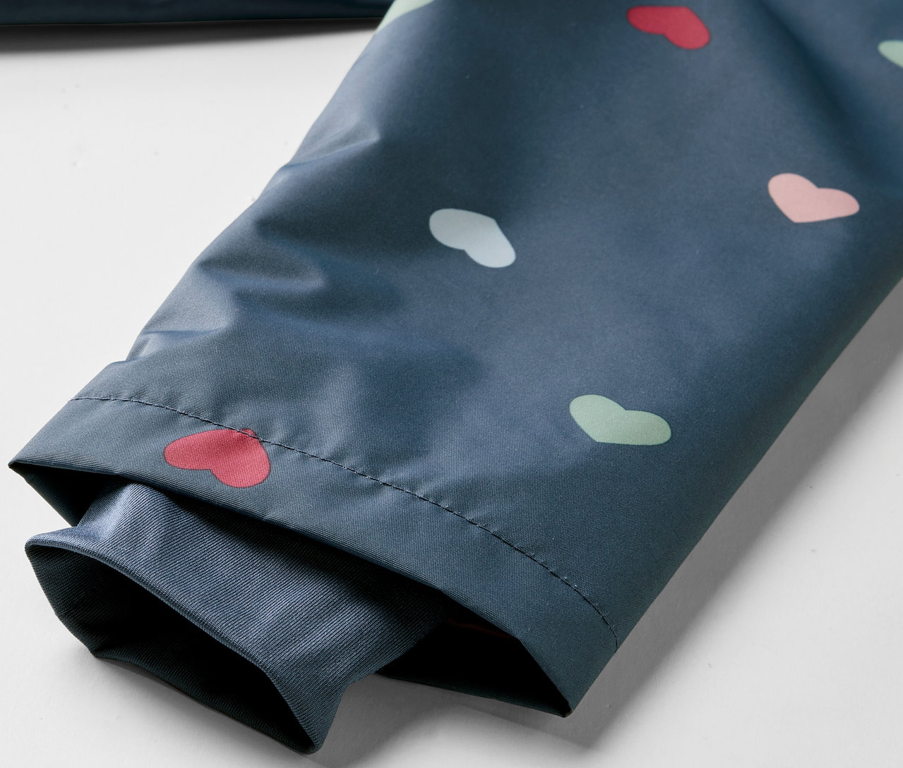 Fragment kurtki przeciwdeszczowej termoaktywnej w serduszka.