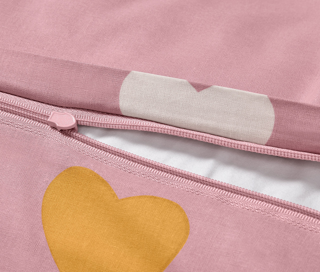 Detal pościeli dziecięcej z bawełny renforcé w standardowym rozmiarze z różowym tłem i złotym sercem.