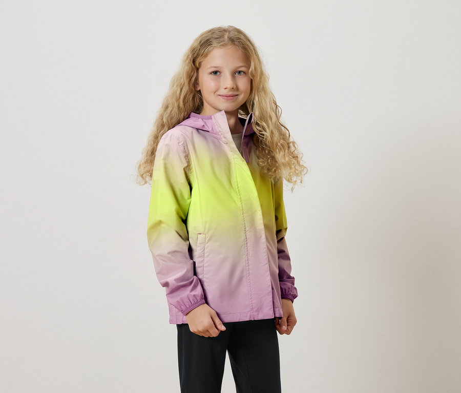 Dziewczyna z długimi blond lokami ma na sobie kurtkę z kapturem z gradientem kolorów od żółtego do fioletowego.