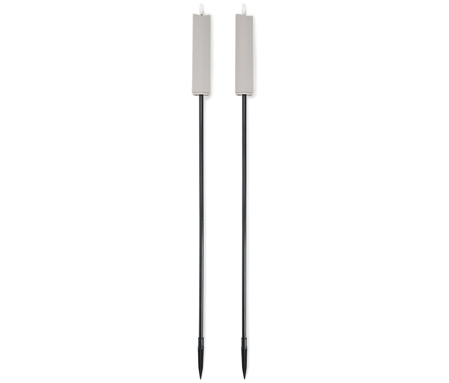 Dwa beżowe pochodnie ogrodowe z czarnymi trzonkami stoją obok siebie na białym tle.